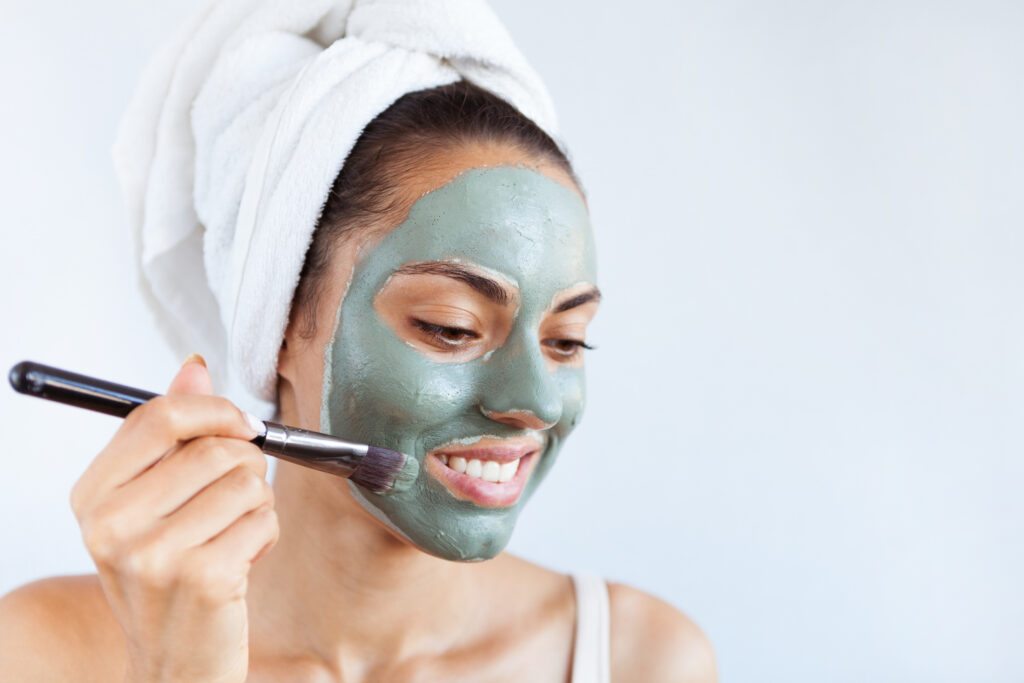 A woman applying a facial mask for her DIY spa day. | The Dating Divas.com 