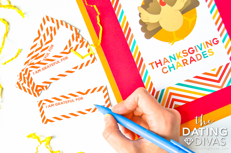 A girl writing on her free Thanksgiving charade ideas printable for game night | The Dating Divas