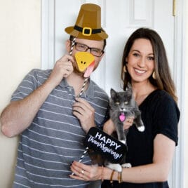 Couple using Thanksgiving photo booth props | The Dating Divas