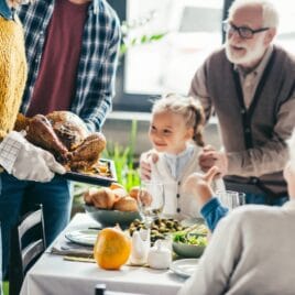 Little girl and grandpa looking at parents bringing in turkey | The Dating Divas