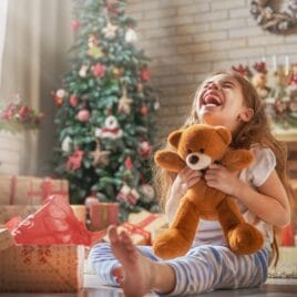 Little girl opening Christmas gift, teddy bear | The Dating Divas