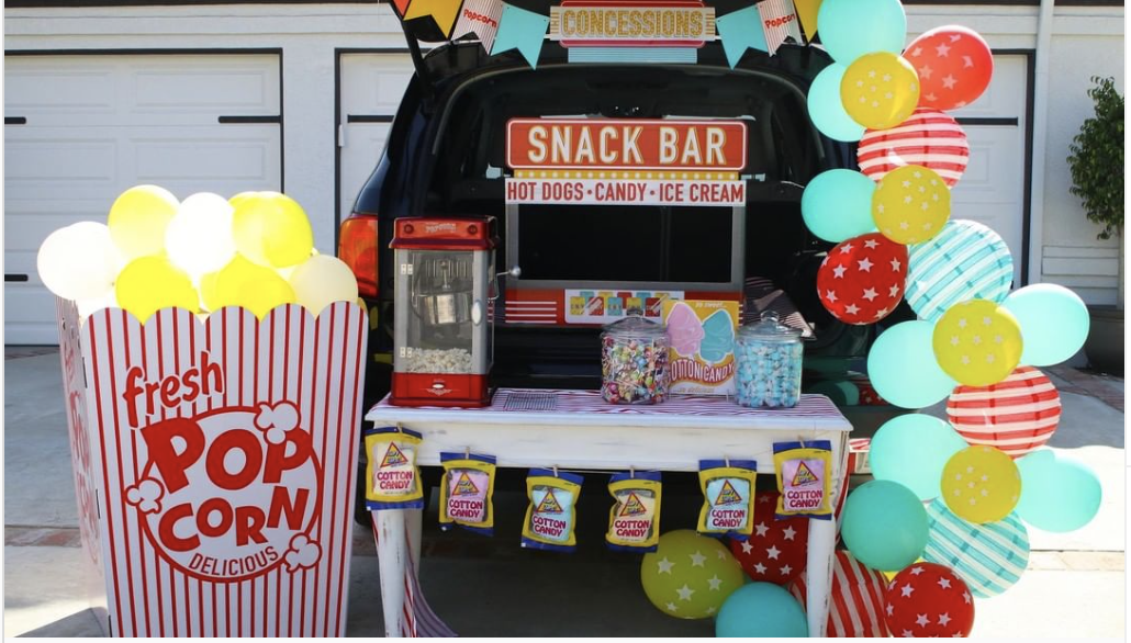 A trunk decorated with a snack bar and popcorn maker to create a concession stand theme for a trunk or treat event | The Dating Divas