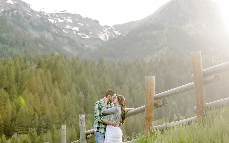 A couple leans against a fence for a photo. | The Dating Divas