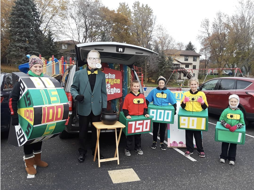 A family dressed as characters from the tv show The Price is Right standing in front of a decorated trunk for a trunk or treat event | The Dating Divas