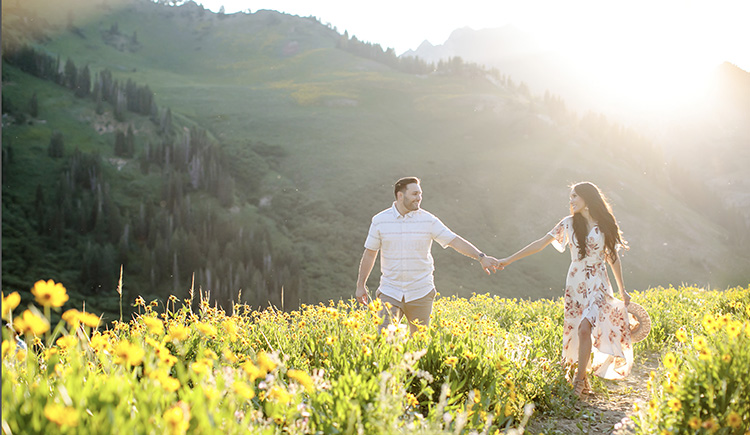 Cute couple poses in a wildflower field. | The Dating Divas