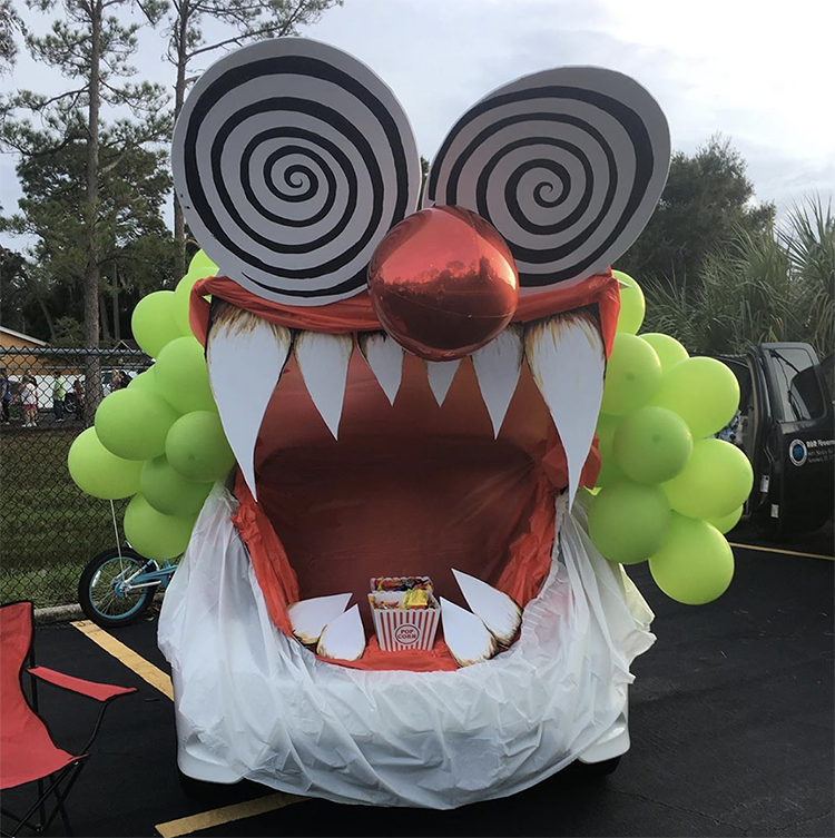 A trunk decorated as a large mouth of a crazy circus clown. The trunk is the mouth of the monster. This is a very popular and easy trunk or treat idea. | The Dating Divas