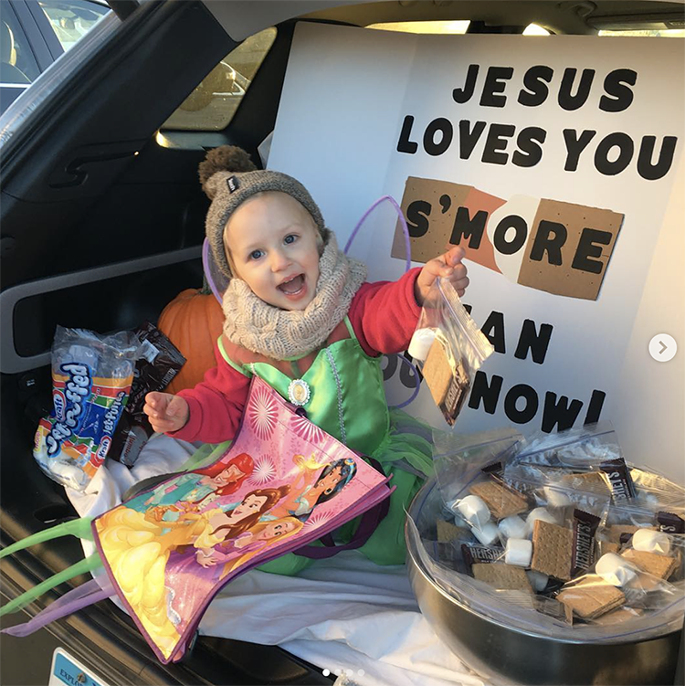 A trunk decorated with a sign that says "Jesus loves you s'more than you know". The treat for the trunk or treat activity is a bag of supplies to make s'mores. | The Dating Divas