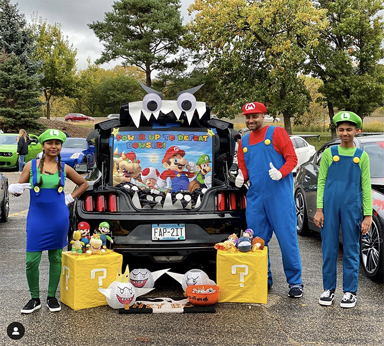 A trunk decorated to the theme of the video game Mario Cart. The family is dressed as characters from Mario cart to match the trunk's Halloween Trunk or Treat theme. | The Dating Divas