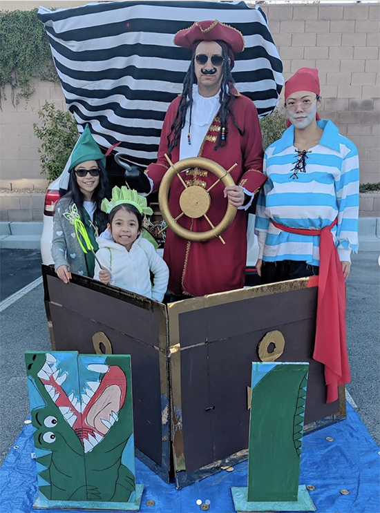 Trunk decorated with a theme for the movie Peter Pan . It includes a large pirate ship, a cardboard cut out of the crocodile. The family is dressed in coordinating Peter Pan Halloween costumes. This is a great trunk or treat idea | The Dating Divas