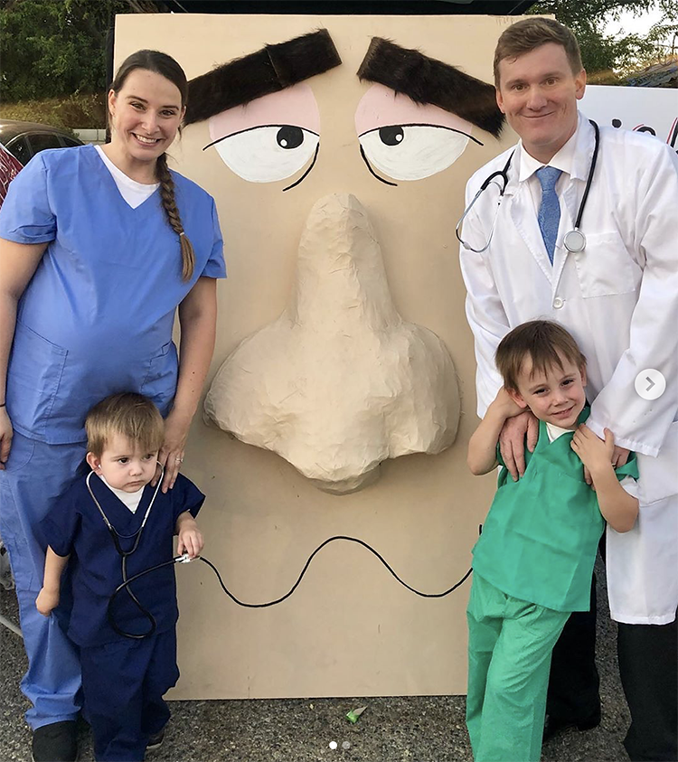 This trunk or treat display is a large face with a large nose. The family is dressed in medical doctor costumes. The idea for this display is for the children to reach up the nose to pick their treat. A really interactive trunk or treat idea. | The Dating Divas