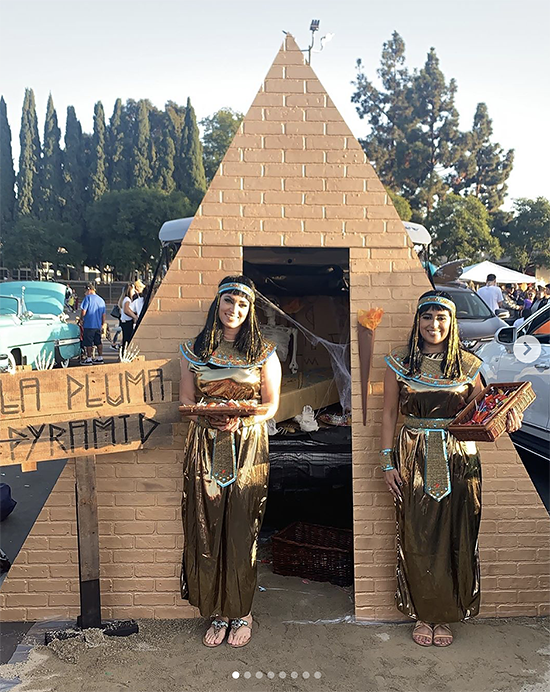 A trunk elaborately decorated with a cardboard replica of the pyramids of Giza. The people giving out candy are dressed as ancient Egyptians. A clever Halloween trunk or treat theme. | The Dating Divas