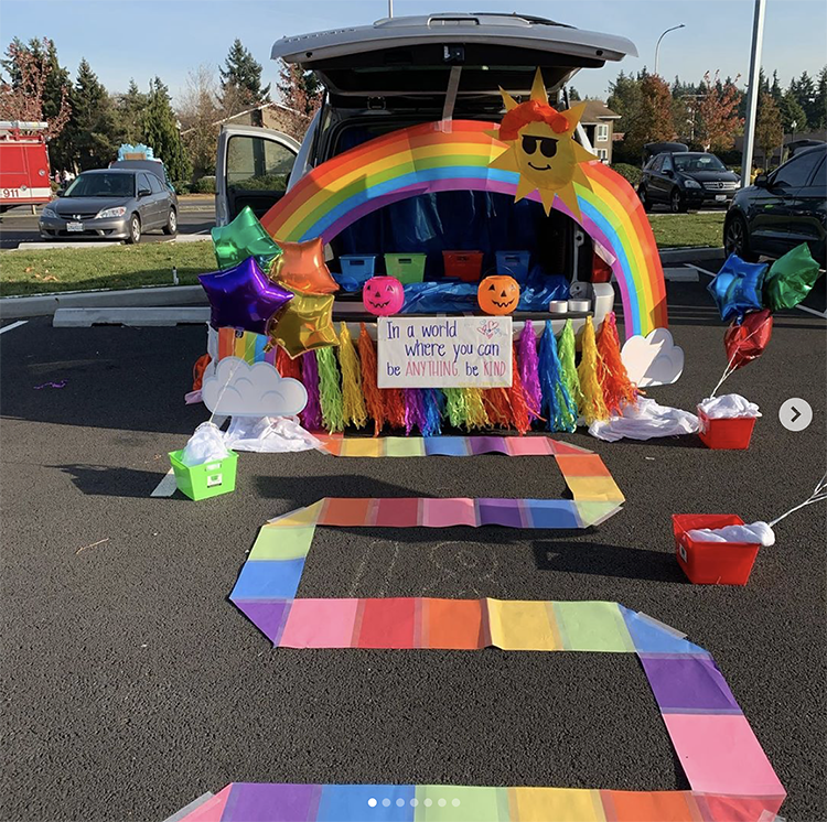 A trunk decorated with the colors of the rainbow. There is a pathway leading two the car which has a large rainbow stretched across the back of the trunk. This is a super popular trunk or treat theme for a Halloween event. | The Dating Divas