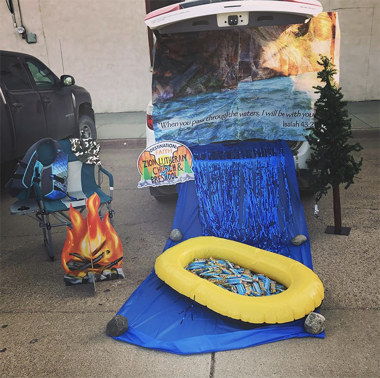 A trunk decorated with a river spilling out of the car. A small raft is placed on the river and filled with candy. A sign includes a quote from Isaiah in the Bible about passing through the waters with the Lord with you. | The Dating Divas