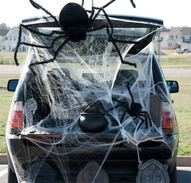 A trunk decorated as a spider web. It has a giant large spider and the trunk is filled with cobwebs. This is an easy trunk or treat idea for decorating your trunk for Halloween. | The Dating Divas