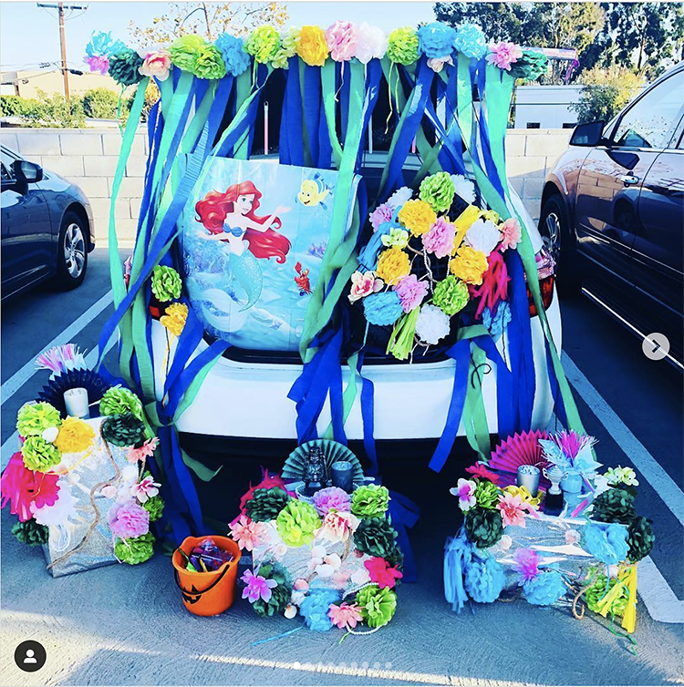 Trunk decorated with a theme for the Disney movie The Little Mermaid. It includes a lot of blue streamers and scenes from the movie. This is a great trunk or treat idea | The Dating Divas