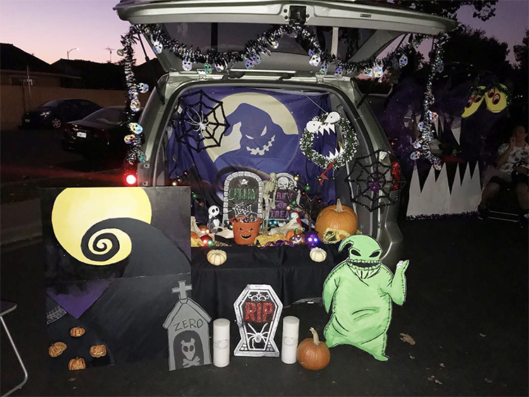 Trunk decorated with a theme for the movie The Nightmare Before Christmas. It includes cutouts with scenes and characters from the movie. This is a great trunk or treat idea | The Dating Divas