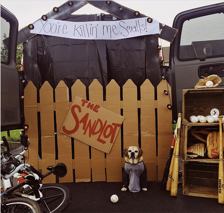 Trunk decorated with a theme for the movie Sandlot. It includes a picket fence, a sign and baseball bats and balls. This is a great trunk or treat idea | The Dating Divas