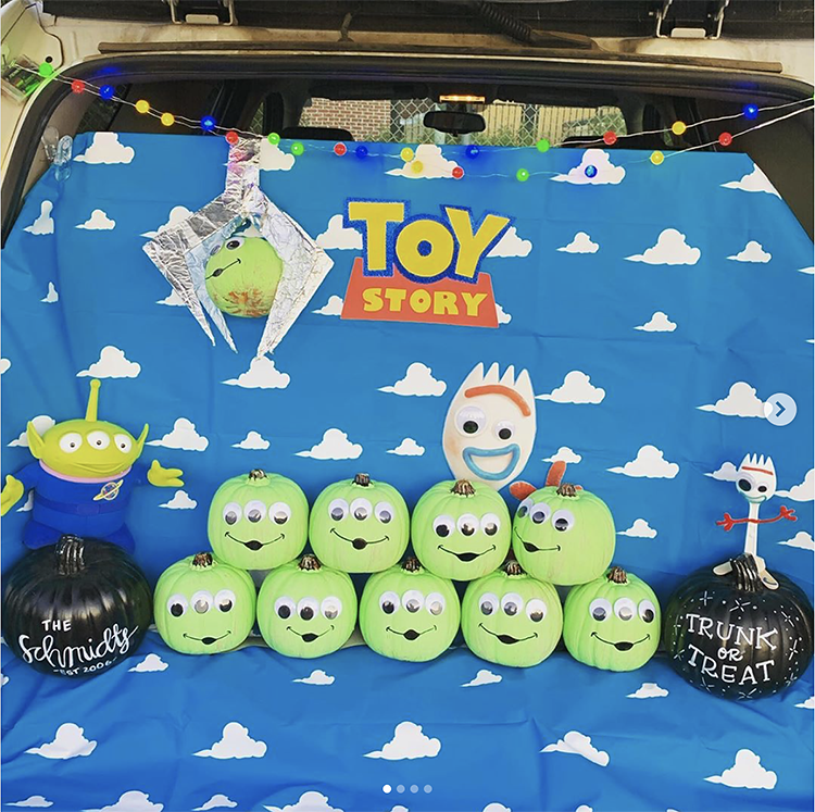 Trunk decorated with a theme for the Disney movie Toy Story. It includes pumpkins decorated as the green aliens from Pizza Planet. This is a great trunk or treat idea | The Dating Divas