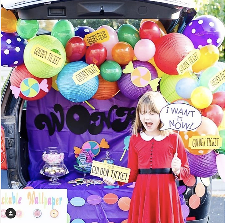 Trunk decorated with a Charlie and the Chocolate Factory theme. It includes a lot of colorful balloons, and some printed golden ticket labels. This is a great trunk or treat idea | The Dating Divas