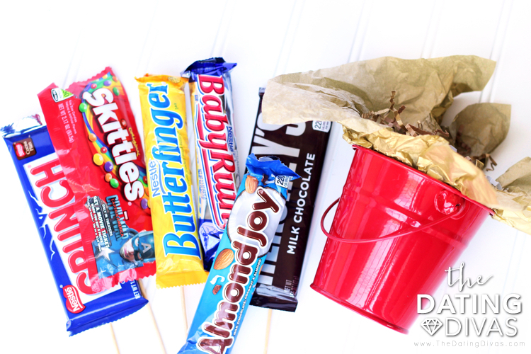 Red bucket and candy bars to build a DIY candy bouquet for that special someone. | The Dating Divas