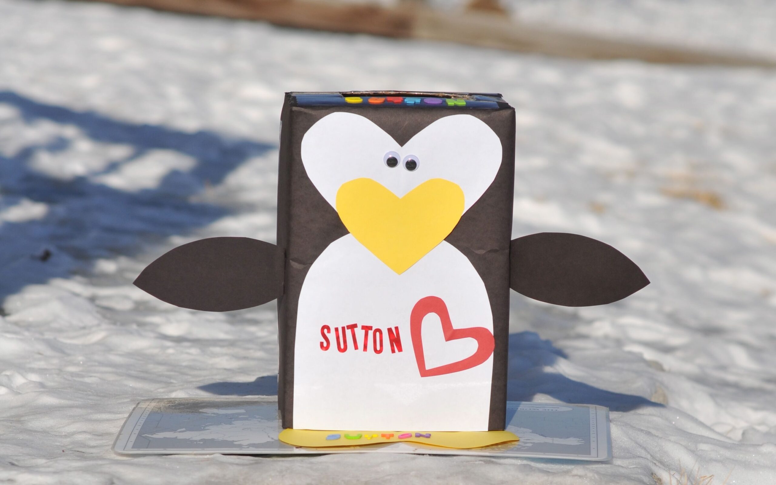 Adorable penguin with a yellow heart nose valentine box idea | The Dating Divas