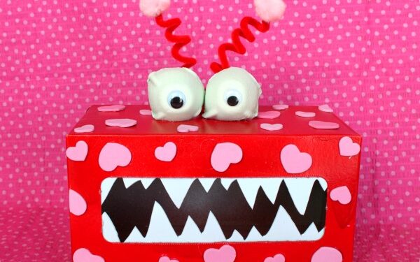 A red monster box covered in pink hearts for Valentine's Day cards | The Dating Divas