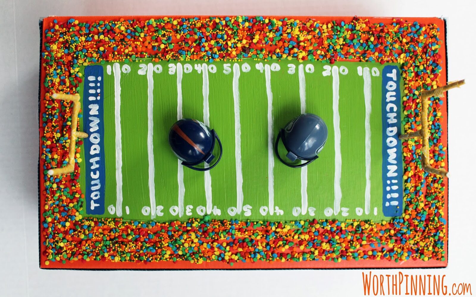 Bright football field themed box with football helmets on top for Valentine's Day | The Dating Divas 