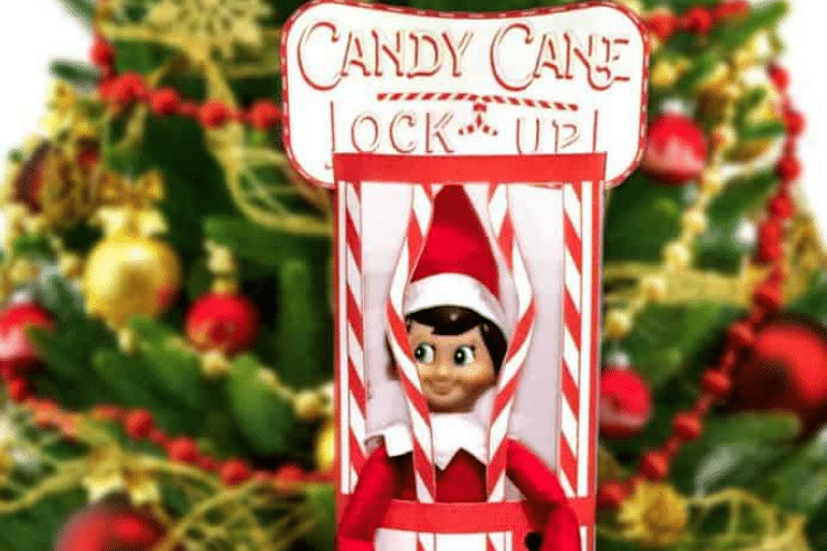 Elf on the shelf behind candy cane jail bars | The Dating Divas