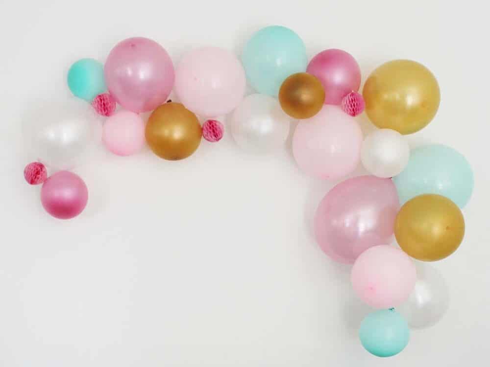 Colorful balloons arranged in an arc on the wall makes for a great birthday party decoration | The Dating Divas