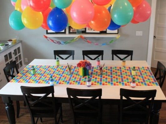 Chandelier created with balloons hangs over the dining area for birthday party decorations | The Dating Divas