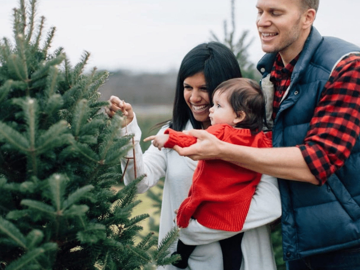 A Christmas photo that shows a young family at a tree farm | The Dating Divas