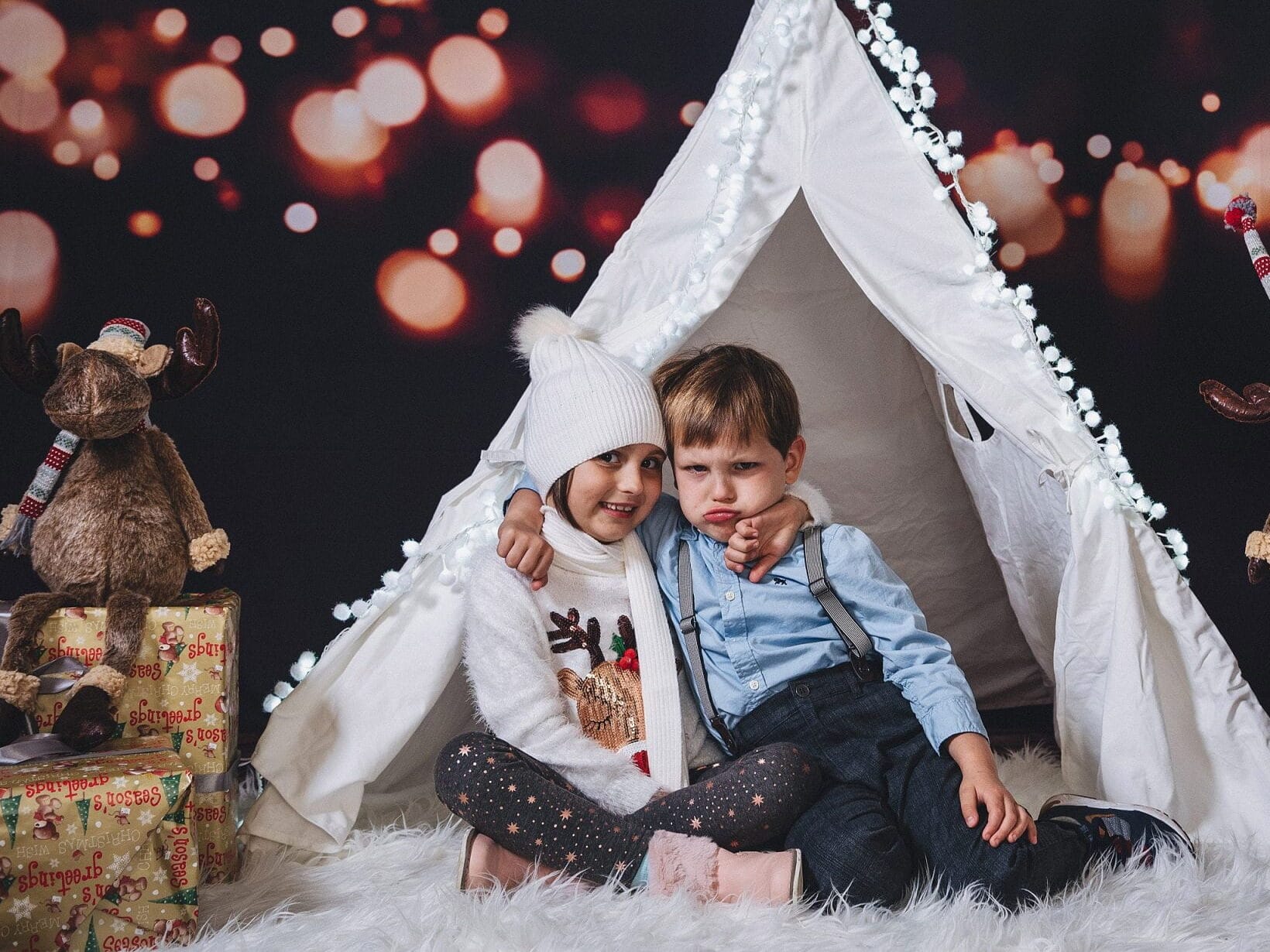 Family Christmas pictures that show two young children sitting in front of a tent | The Dating Divas