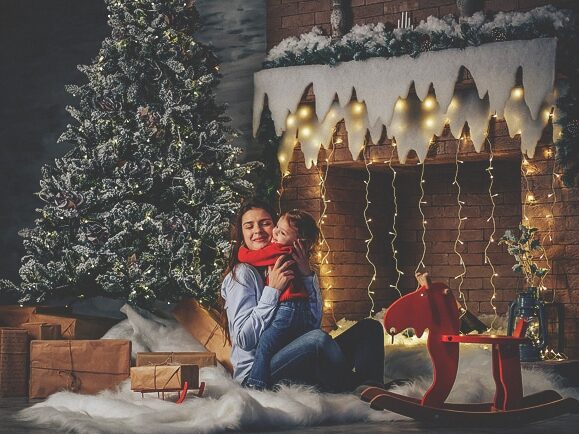 Family Christmas card ideas showing a mother and child in front of the fireplace | The Dating Divas