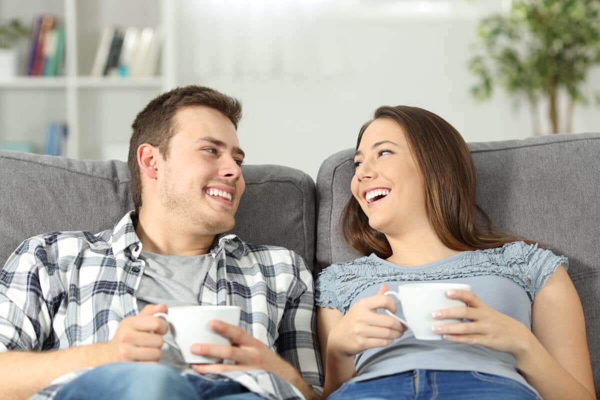 A man and woman communicating in their relationship while sitting at home together | The Dating Divas