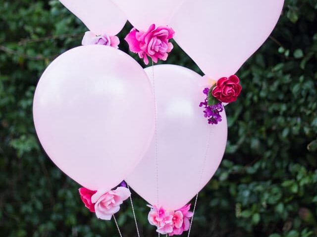 Add flowers to the bottom of balloons for a whimsical birthday decoration idea | The Dating Divas