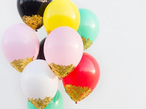 Apply glitter to the bottom of balloons to make sparkly birthday party decorations | The Dating Divas