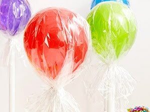 Balloons wrapped in cellophane to make lollipop balloons at a kid's birthday party | The Dating Divas