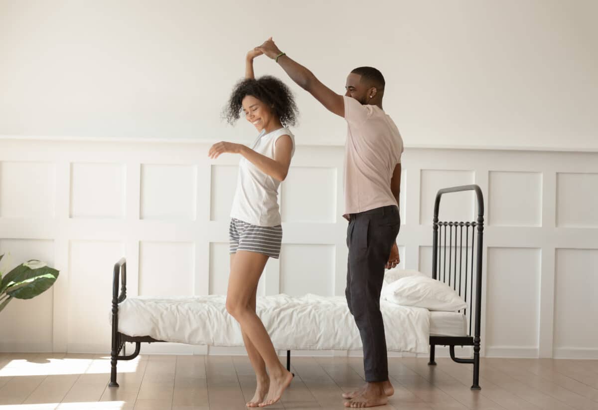 A man and woman discussing low sex drive in women and dancing in their bedroom together | The Dating Divas