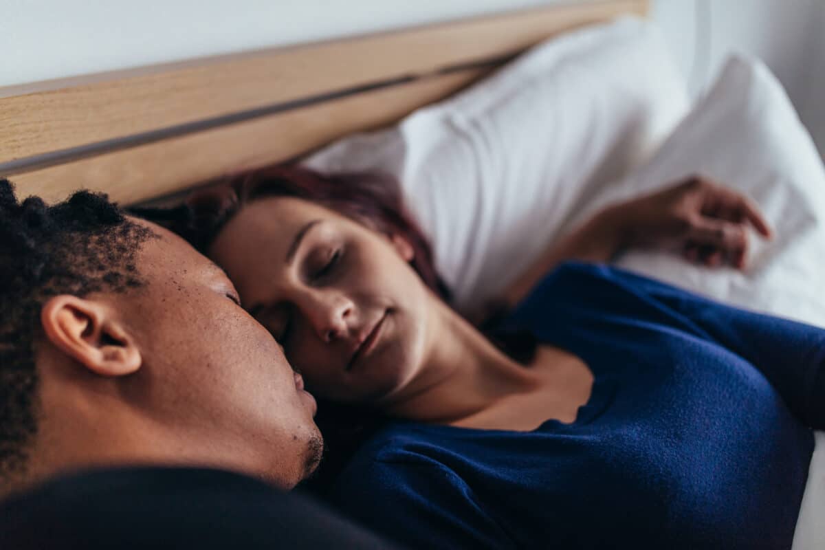 A husband and wife lying in bed enjoying the benefits of their sex therapy session. | The Dating Divas