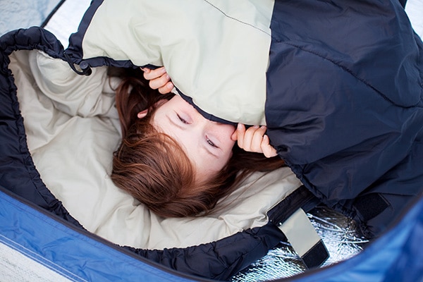 A young kid camping in a sleeping bag | The Dating Divas