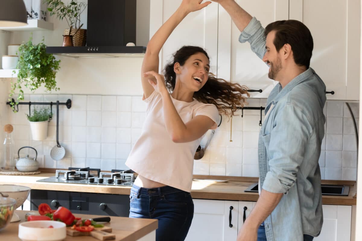 Couple struggling with ADHD in marriage dance happily in the kitchen | The Dating Divas 