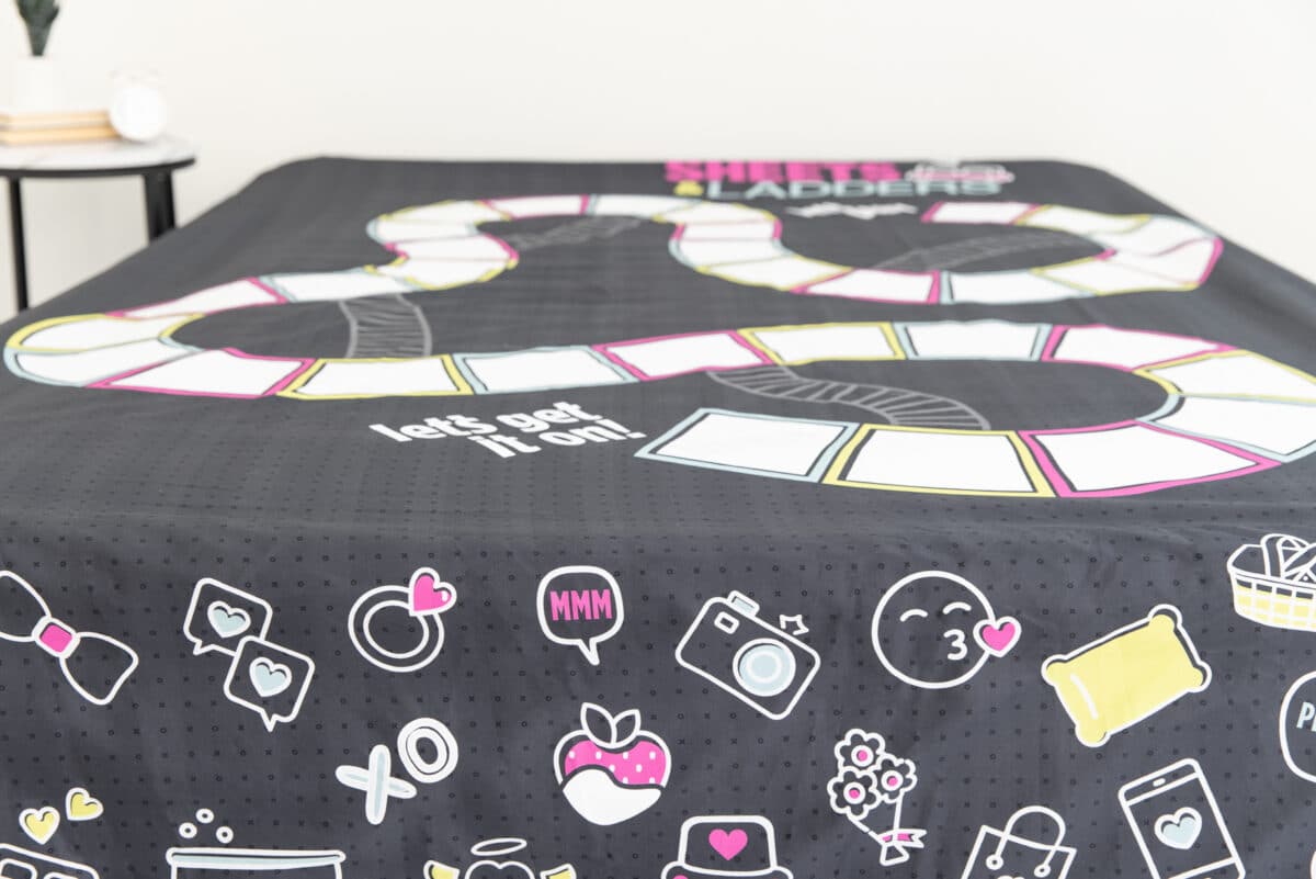 A board game printed right on a bedsheet for a fun foreplay idea in the bedroom | The Dating Divas
