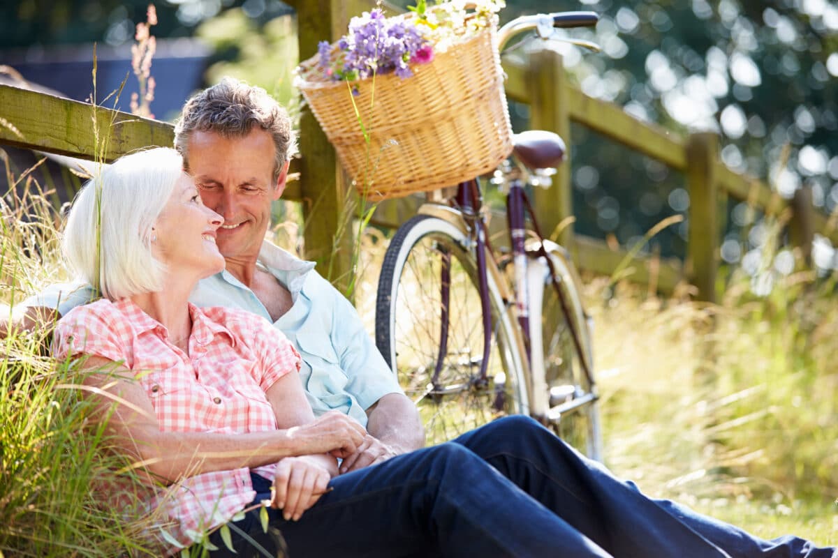 A man and woman enjoying an afternoon bike ride together while conquering empty nest syndrome | The Dating Divas