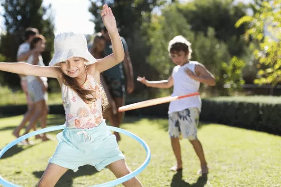 Two kids hula hooping and playing outdoor games | The Dating Divas