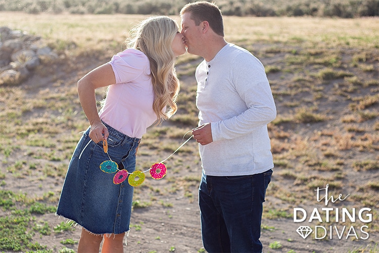 A man and woman kissing with a sweet donut garland on their 6 year anniversary | The Dating Divas