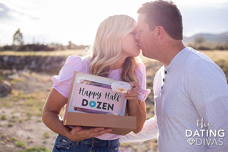 A man and woman kissing and eating donuts for a 6 year anniversary gift idea | The Dating Divas