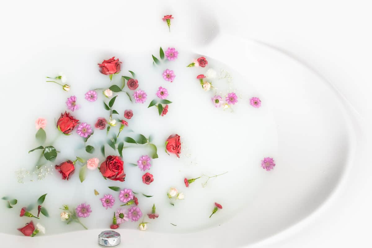 Colorful and beautiful flowers in a milk bath setup for a boudoir shoot | The Dating Divas