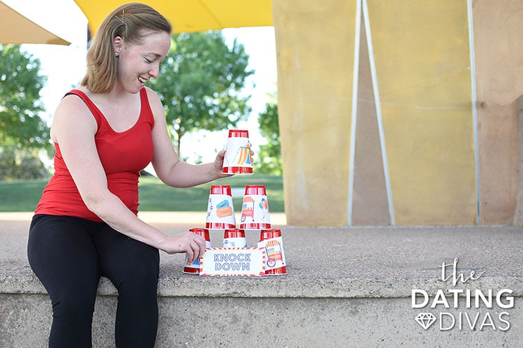 A woman stacking cups for kids carnival games | The Dating Divas