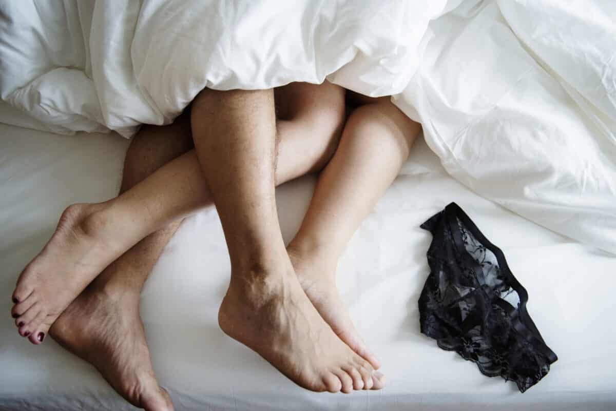 A husband and wife in bed together trying out a couple date ideas for sex and intimacy | The Dating Divas
