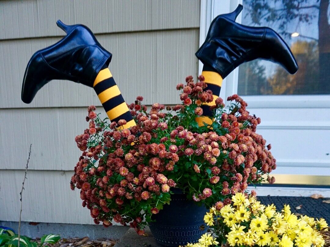 Put fake witch legs in a planter to surprise your neighbors with your DIY Halloween decor. | The Dating Divas